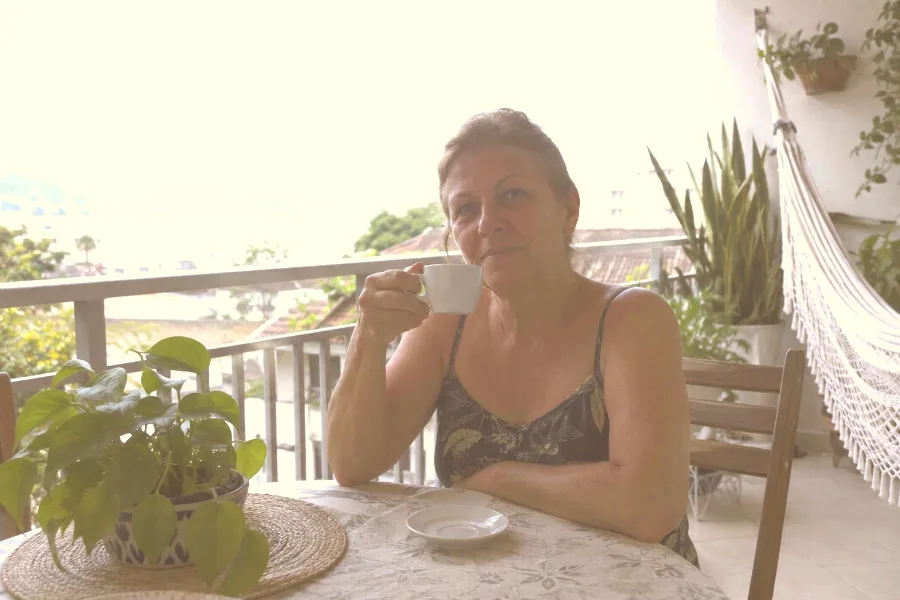 Depois: Mulher tomando café na varanda